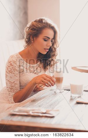 Beautiful blonde girl 20-24 year old drinking coffee in cafe. Good morning. Breakfast time.