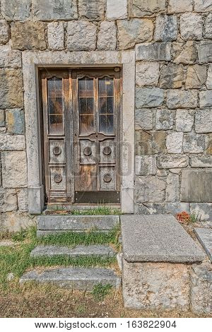 Brown old wooden door of the typical house in Tucepi village, Croatia.