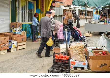 Rivne, Ukraine - May 14, 2013: People at local farmers market or bazaar walking selling and buying fruits and vegetables
