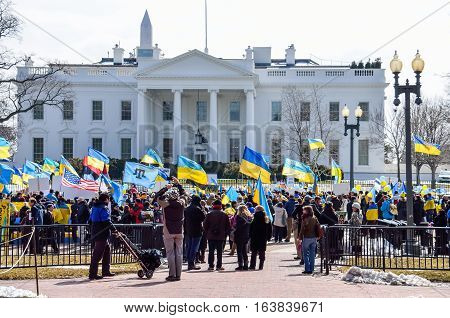 Washington DC, USA - March 6, 2014: Crowd of people at Ukrainian protest by White House with flags and monument