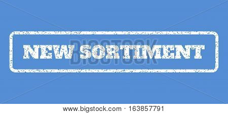 White rubber seal stamp with New Sortiment text. Vector tag inside rounded rectangular shape. Grunge design and unclean texture for watermark labels. Horisontal sticker on a blue background.