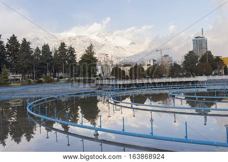 Tehran International Permanent Fairground Pool with Off Fountains Landscape Cityscape of Tehran and Alborz Mountains Covered by Snow at Background.