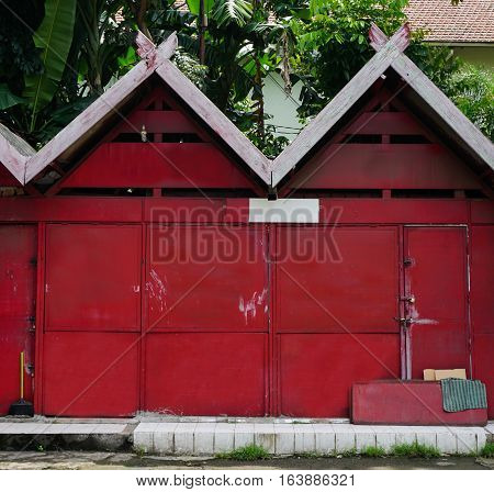 Red store house with green garden inside photo taken in Semarang indonesia java