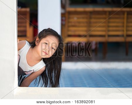 Adorable little girl playing peekaboo asian child