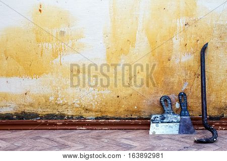 Construction background. Old wall spaces in which to make repairs. The wall, located the nail puller and spatulas.