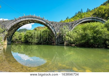 Three arches stone bridge of Kalogeriko (or Plakida) on the river of Voidomatis near the villages of Kipi and Koukouli in the Central Zagori. Greece