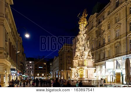 VIENNA, AUSTRIA - MAY 17, 2016: Photo view on memorial plague column pestsaule and tourists on graben street at night with people