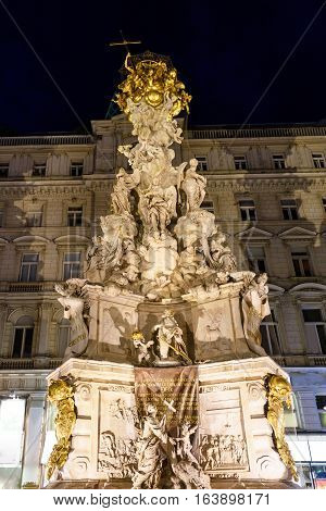 Photo view on memorial plague column pestsaule and tourists on graben street at night, vienna, austria