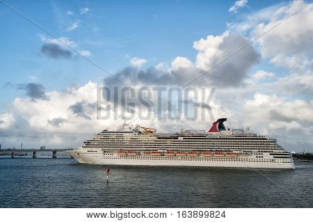 Miami USA - December 27 2015: Beautiful marine view with one large cruise liner ship of Carnival cruise line in port going to destination on cloudy blue sky backgroundat Miami Florida