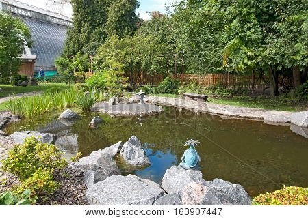 Saint-Petersburg, Russia, August 3, 2016: Woman near The Japanese Garden with pond in Peter the Great Botanical Garden (Botanic Gardens of the Komarov Botanical Institute of the Russian Academy of Sciences.
