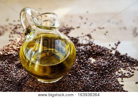 linseed oil in a glass jug and flax seeds on a wooden table healthy with omega 3 fatty acids selected focus narrow depth of field