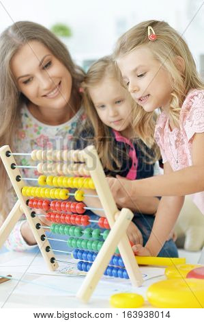 mother with two little daughters counting on counter