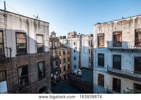 Brownstones and urban dwellings in between blocks in New York City on a clear day in the afternoon