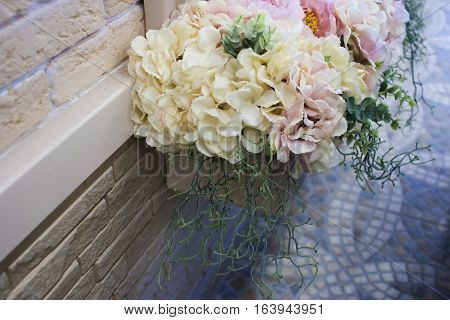 Yellow And Pink Flowers In A Pot On A Wall