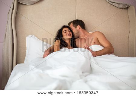 Young couple in bed. Caucasian man and woman. Live and love each other.