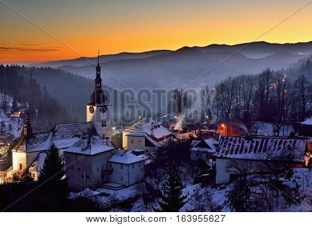 Sunset at winter in Slovakia. Old mining village. Historic church in Spania Dolina.