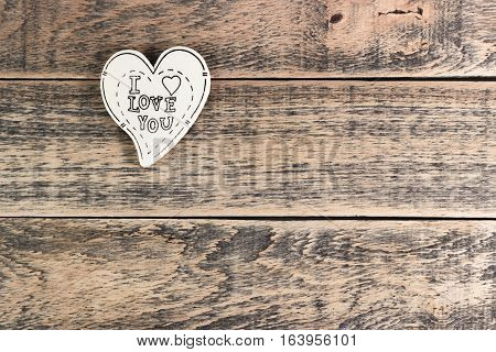 Wooden heart on wooden texture with empty space