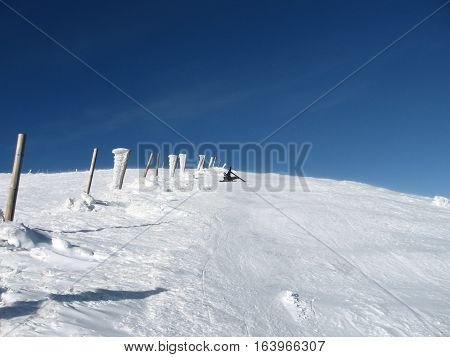 Skier fell on top of the ridge the snow-covered landscape