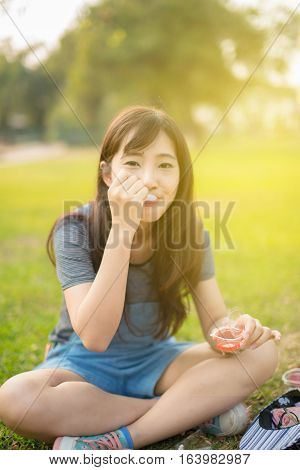 Woman eating A Piece Of cake in Park