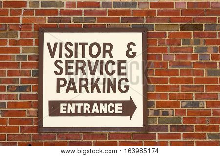 Business sign directing visitors and service representatives to parking area and entrance