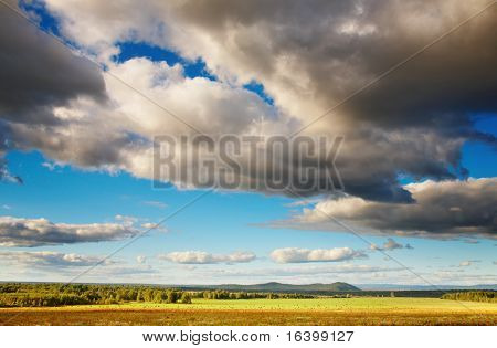 Krajina s zamračená obloha, lesní a hayfield