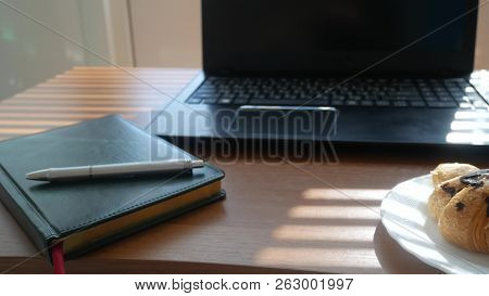 A Businessmans Desk With A Disposable Cup For Coffee And Fast Food. Open Laptop Computer. Breakfast 