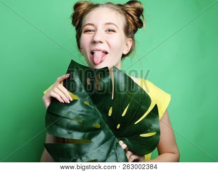 funny girl showing her tongue while posing against studio background.