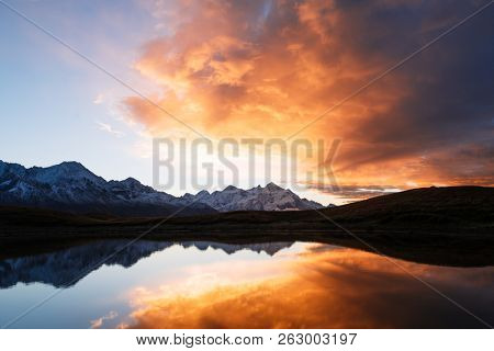 Mountain Lake Koruldi. Morning landscape with beautiful sky and sunshine. Reflection in water. Main Caucasian ridge. Zemo Svaneti, Georgia