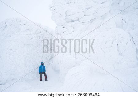 Rime and firn on rocks in mountains. Severe winter hike. Landscape with snow and fog
