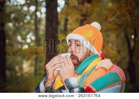 Mature Man In Jacket Suffering From Cold. Blowing Nose With A Tissue, Looking Miserable Unwell Very 