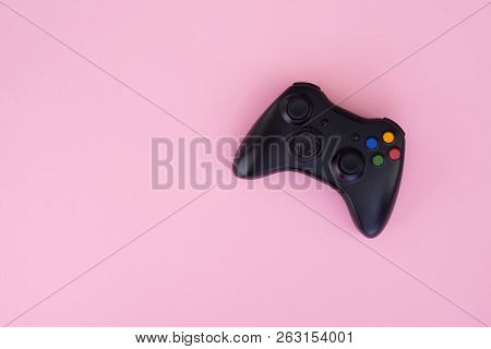 Black Joystick Is Isolated On A Pastel Pink Background. Video Game Competition. Gaming Concept. Copy