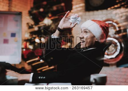Businessman In Red Cap In Office On New Year Eve. Christmas Tree In Office. Business Concept. Man In