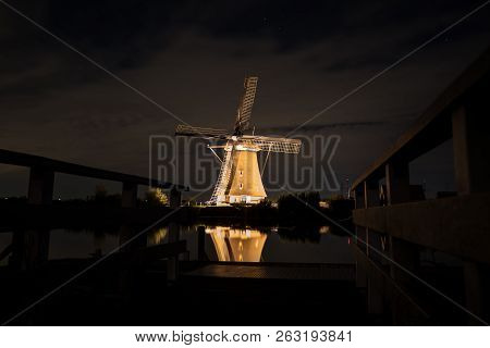 These Beautiful Windmills In Kinderdijk Are Illuminated With White Light At The Blue Hour
