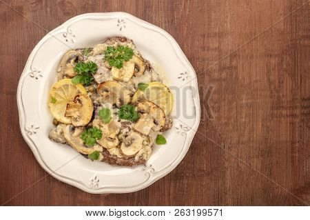 A Photo Of Scallopine Di Vitello, Veal Scallopini, With A Mushroom Sauce, Lemons, And Parsley, Shot 