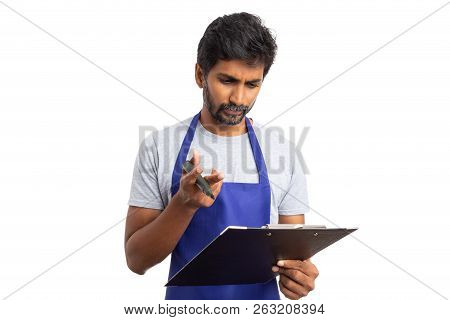 Indian Male Store Manager Looking At Vendor Checklist With Concerned Expression Isolated On White St