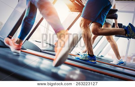 Group Of Friends Exercising On Treadmill Machine
