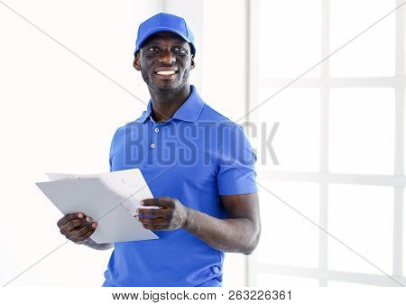 Portrait Of An Handsome Happy Deliverer With Folder
