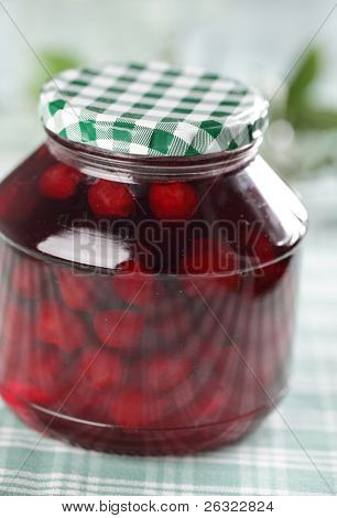 Canned sour cherry compote on the table