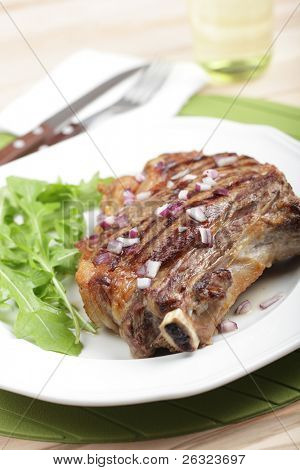 붉은 양파와 로켓 샐러드와 구운된 갈비 스테이크