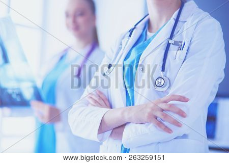 Close Up Shoot Of Doctor's Crossed Hands And Colleague With X-ray On The Background.