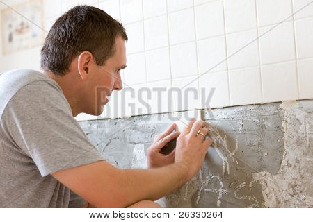 Homem azulejos uma parede na cozinha