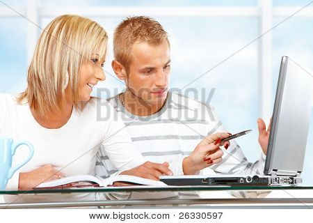 Портрет Счастливая пара с ноутбуком в доме или офисе