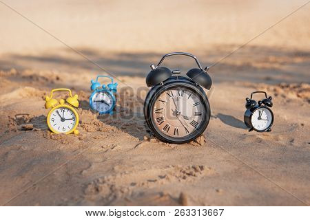 Vintage Black Alarm Clock On Autumn Leaves. Time Change Abstract Photo.