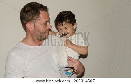 Father And Son Playng With Moustache Funny Faces
