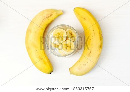 Sliced ​​banana In The Glass With Two Bananas On The Side
