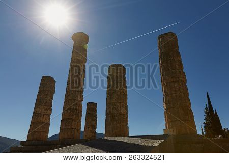 Low Angle View Of The Temple Of Apollo At Delphi, Greece With Sun Star Effect.