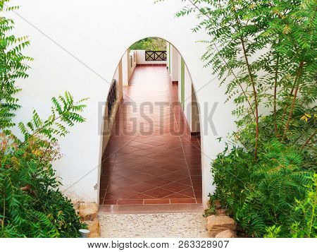 Arched Entrance With Some Greenery. Archway To The Rooms At The Resort