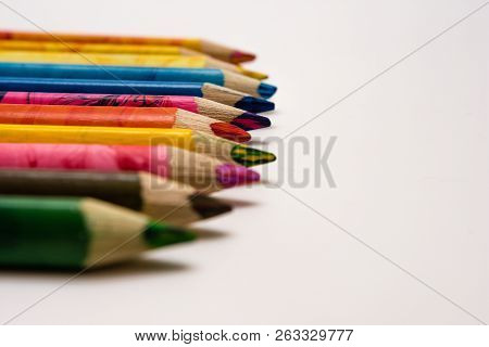Set Of Colored Pencils Lying On The Notebook. White Background. Isolate. Christmas Colors