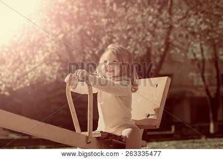 Happy Childhood, Activity, Lifestyle. Girl Smile On Seesaw On Sunny Day. Balance, Equilibrium, Harmo