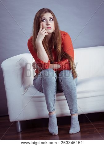 Angry, Pissed Off Young Woman. Attractive Female With Long Brown Hair Sitting On Sofa Being Mad And 